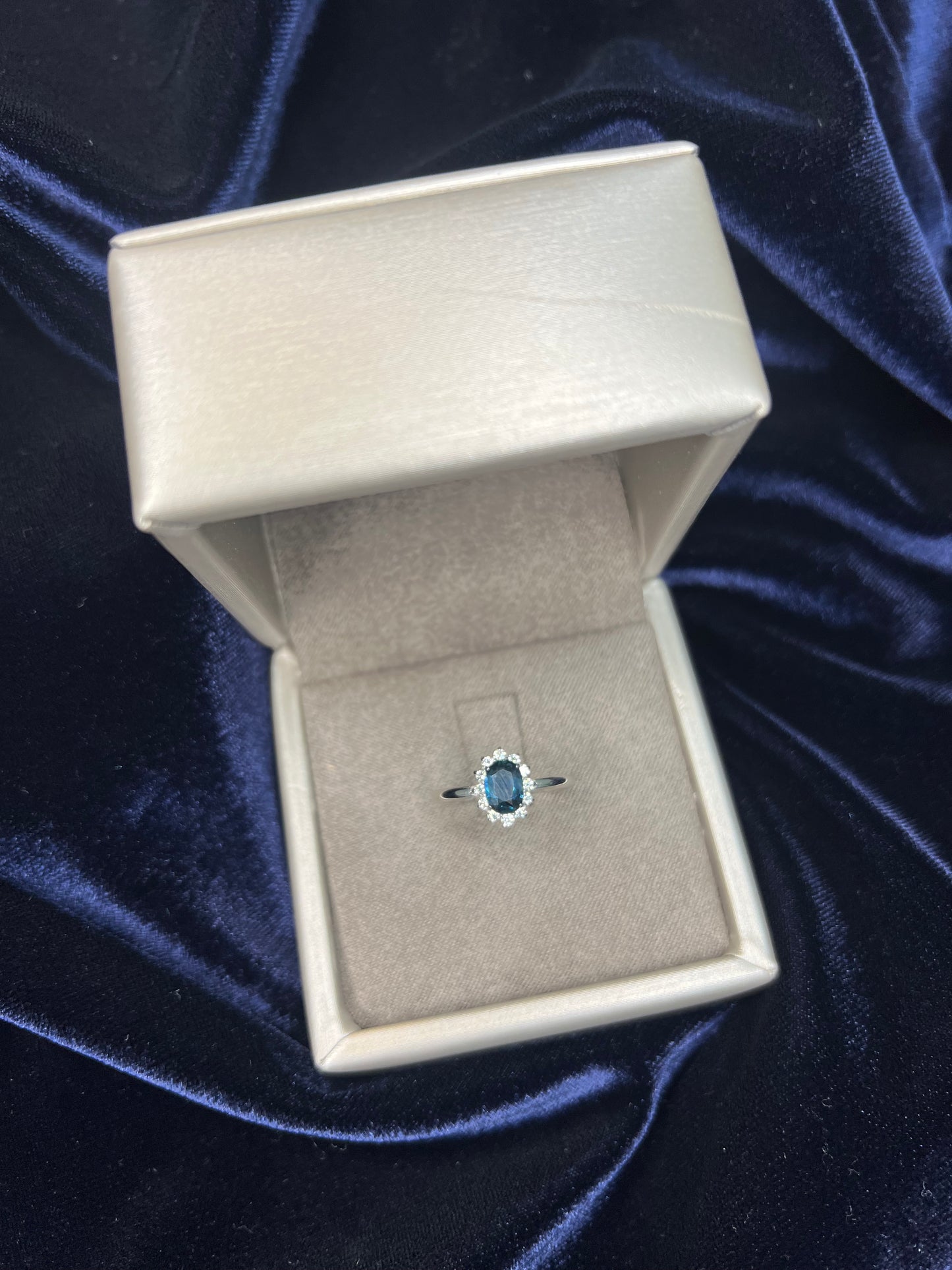 Anillo orla con piedra central de color y diamantes en oro de 18 K